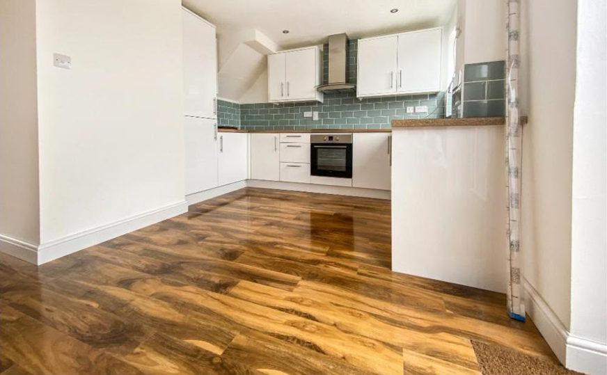 Finished open-plan kitchen with hardwood flooring by DR Smith Building.